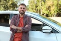 Handsome young driver near modern car on city street Royalty Free Stock Photo