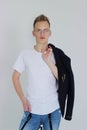 Handsome young fashion male model posing with jacket over his shoulder. Royalty Free Stock Photo