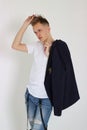 Handsome young fashion male model posing with jacket over his shoulder. Royalty Free Stock Photo