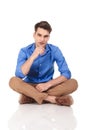Handsome young fashion man sitting with his legs crossed. Royalty Free Stock Photo