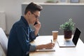 Handsome Young Freelancer Guy Talking On Cellphone And Taking Notes To Notepad Royalty Free Stock Photo