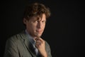 Handsome young freelancer man looking at camera with a strong look wearing suit jacket isolated on black background Royalty Free Stock Photo