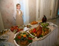 A handsome young girl waiter presents an impressive buffet in a Russian restaurant.