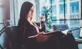 Handsome young girl wearing glasses casual clothes holding book hands.Woman blonde sitting in vintage armchair modern Royalty Free Stock Photo