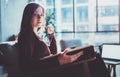 Handsome young girl wearing glasses casual clothes holding book hands.Woman blonde sitting in vintage armchair modern Royalty Free Stock Photo