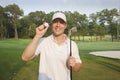 Handsome young golfer holds club and ball on a course Royalty Free Stock Photo