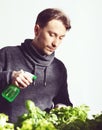 Handsome young grower carefully irrigating plants indoor. Cuisine, nutrition, vegetarian and growing concept.