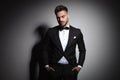 Handsome young guy in black tuxedo holding hands in pockets Royalty Free Stock Photo