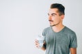 Young guy holding a cup of coffee on white isolated background.