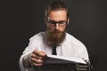 Handsome young hipster businessman thinking and writing with vintage typewriter. Royalty Free Stock Photo