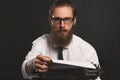 Handsome young hipster businessman thinking and writing with vintage typewriter. Royalty Free Stock Photo