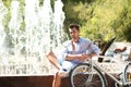 Handsome young hipster man sitting with bicycle Royalty Free Stock Photo