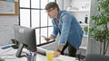 Handsome young hispanic man, an attractive boss working at the office desk, reading through important business documents while Royalty Free Stock Photo