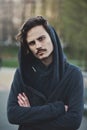 Handsome young hooded man looks on something with suspicion Royalty Free Stock Photo