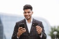 Handsome young Indian man in eyeglasses, using smart phone and holding credit card Royalty Free Stock Photo