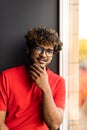 Handsome young indian man sits home on windowsill