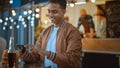 Handsome Young Indian Man is Using a Smartphone while Sitting at a Table in a Outdoors Street Food Royalty Free Stock Photo