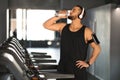 Handsome Young Male Athlete Drinking Water While Training At Treadmill At Gym, Royalty Free Stock Photo