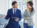 Ill find you a great deal. a handsome young male car salesman talking to a female customer on the showroom floor. Royalty Free Stock Photo