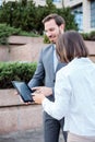 Handsome young male and female business people talking in front of an office building, having a meeting and discussing Royalty Free Stock Photo