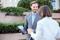 Handsome young male and female business people talking in front of an office building, having a meeting Royalty Free Stock Photo