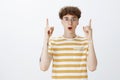 Handsome young male geek in round glasses with curly hairstyle and tattoos being excited and stunned with great idea Royalty Free Stock Photo