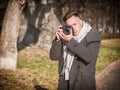 Handsome young male photographer taking photograph outside