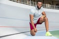 Handsome young male runner standing on one knee Royalty Free Stock Photo