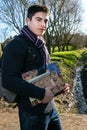 Handsome young teenage male student walking to school in sunshine, carrying books and rucksack Royalty Free Stock Photo