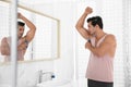 Handsome young man applying deodorant Royalty Free Stock Photo