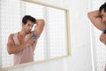 Handsome young man applying deodorant Royalty Free Stock Photo