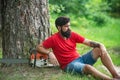 Handsome young man with axe near forest. Lumberjack with chainsaw in his hands. Chainsaw. Deforestation is a major cause