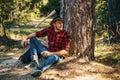 Handsome young man with axe near forest. Lumberjack sitting in the forest. Royalty Free Stock Photo