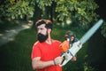 Handsome young man with axe near forest. Stylish young man posing like lumberjack. A handsome young man with a beard Royalty Free Stock Photo