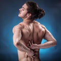 Handsome young man with back pain Royalty Free Stock Photo