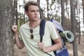 Handsome young man with backpack hiking in forest Royalty Free Stock Photo