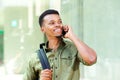 Handsome young man with backpack talking on mobile phone Royalty Free Stock Photo