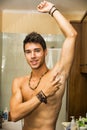 Handsome young man in bathroom, spraying cologne Royalty Free Stock Photo