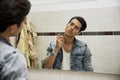 Handsome young man in bathroom, spraying cologne or perfume Royalty Free Stock Photo