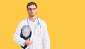 Handsome young man with bear as nutritionist doctor holding weighing machine thinking attitude and sober expression looking self