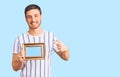 Handsome young man with bear holding empty frame smiling happy pointing with hand and finger Royalty Free Stock Photo