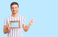 Handsome young man with bear holding empty frame smiling happy pointing with hand and finger to the side Royalty Free Stock Photo