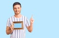 Handsome young man with bear holding empty frame surprised with an idea or question pointing finger with happy face, number one Royalty Free Stock Photo