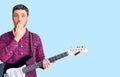 Handsome young man with bear playing electric guitar covering mouth with hand, shocked and afraid for mistake Royalty Free Stock Photo