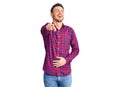 Handsome young man with bear wearing casual shirt laughing at you, pointing finger to the camera with hand over body, shame Royalty Free Stock Photo