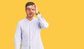 Handsome young man with bear wearing elegant business shirt and glasses doing ok gesture shocked with surprised face, eye looking Royalty Free Stock Photo