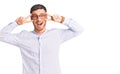 Handsome young man with bear wearing elegant business shirt and glasses doing peace symbol with fingers over face, smiling Royalty Free Stock Photo