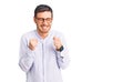 Handsome young man with bear wearing elegant business shirt and glasses excited for success with arms raised and eyes closed Royalty Free Stock Photo