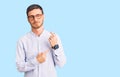 Handsome young man with bear wearing elegant business shirt and glasses in hurry pointing to watch time, impatience, looking at Royalty Free Stock Photo