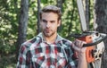 Handsome young man with a beard carries a tree. Woodworkers lumberjack. Firewood as a renewable energy source Royalty Free Stock Photo